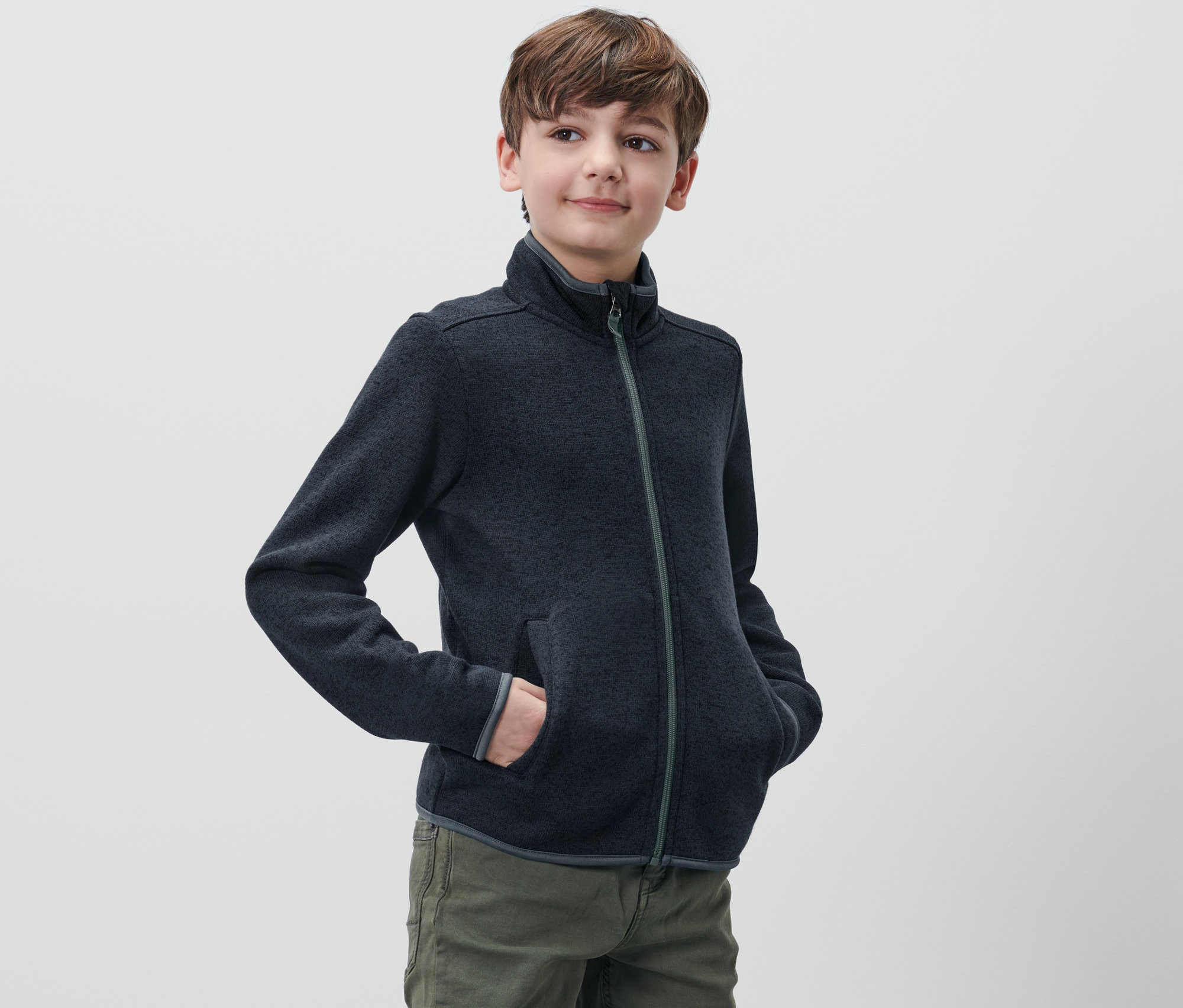Chlapec má na sobě mikinu z pleteného fleecu.