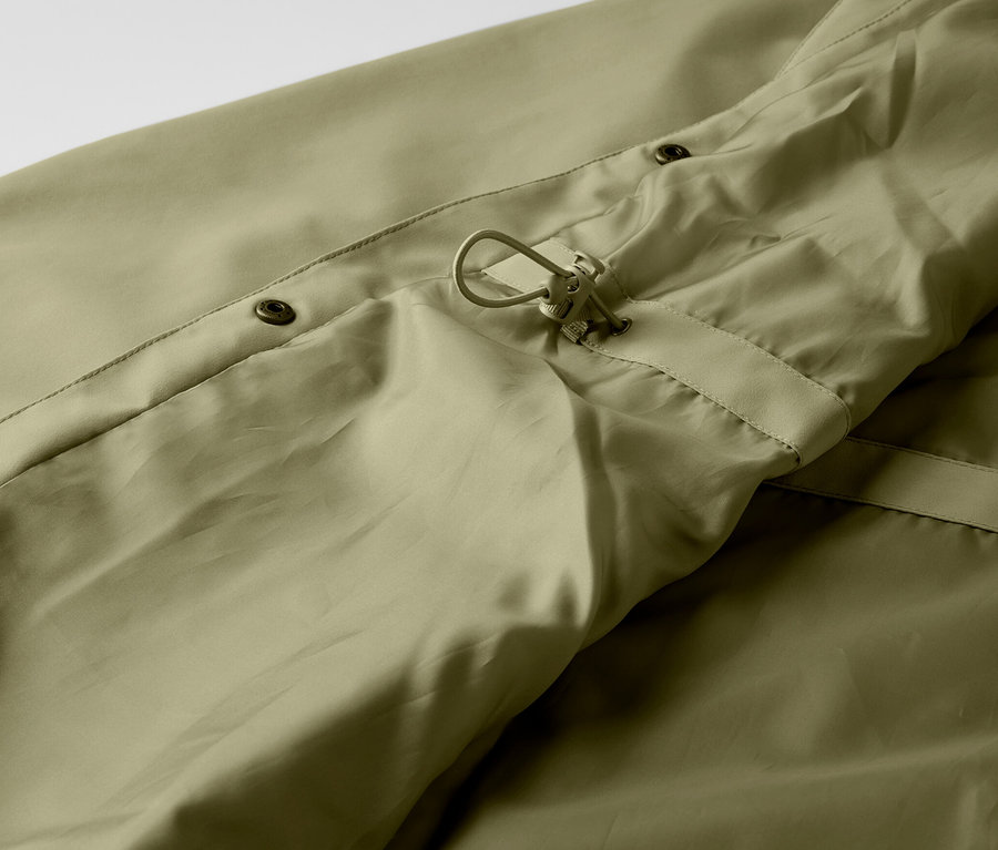 Detail khaki kabátu do deště s knoflíky a stahovací šňůrkou.