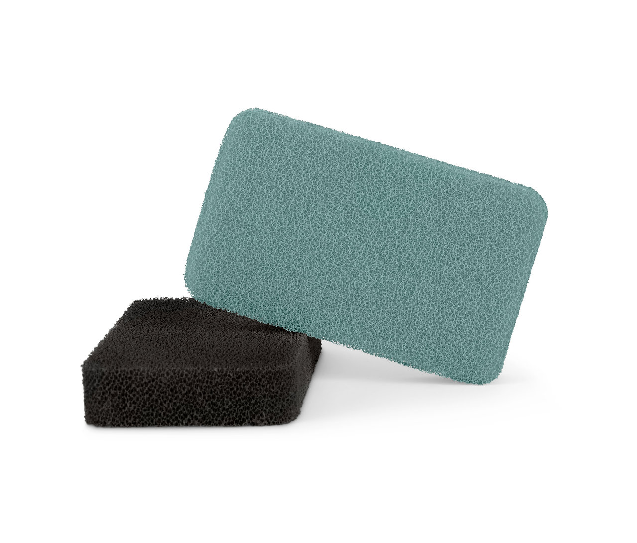 Dvě silikonové houbičky, jedna zelená a jedna černá, leží na sobě.