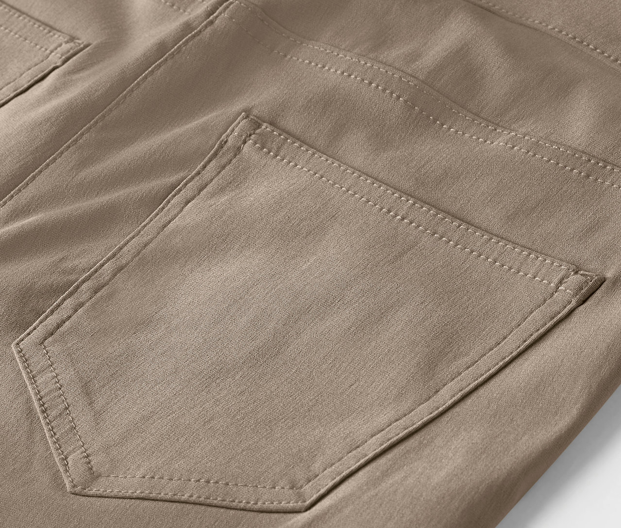 Detail hnědých kalhot s kapsou.