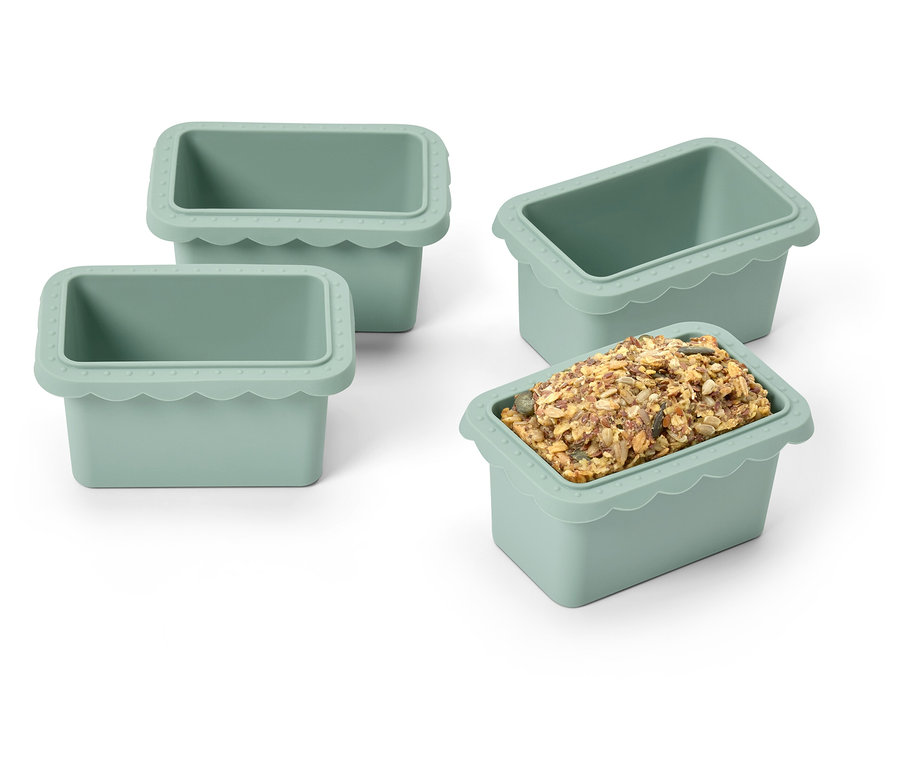 Čtyři zelené silikonové formičky na led, jedna naplněná kostkami ledu.