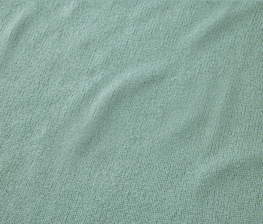 Detail strukturovaného trička šalvějové barvy.