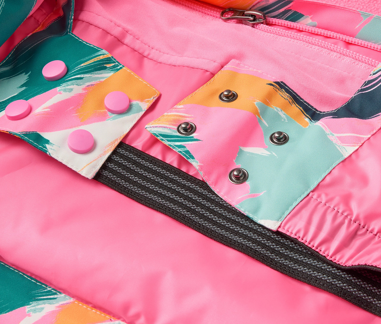 Detail bundy s růžovou podšívkou, barevnými vzory a druky.