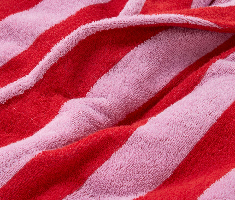 Detailní záběr na červeno-růžovou pruhovanou froté látku.
