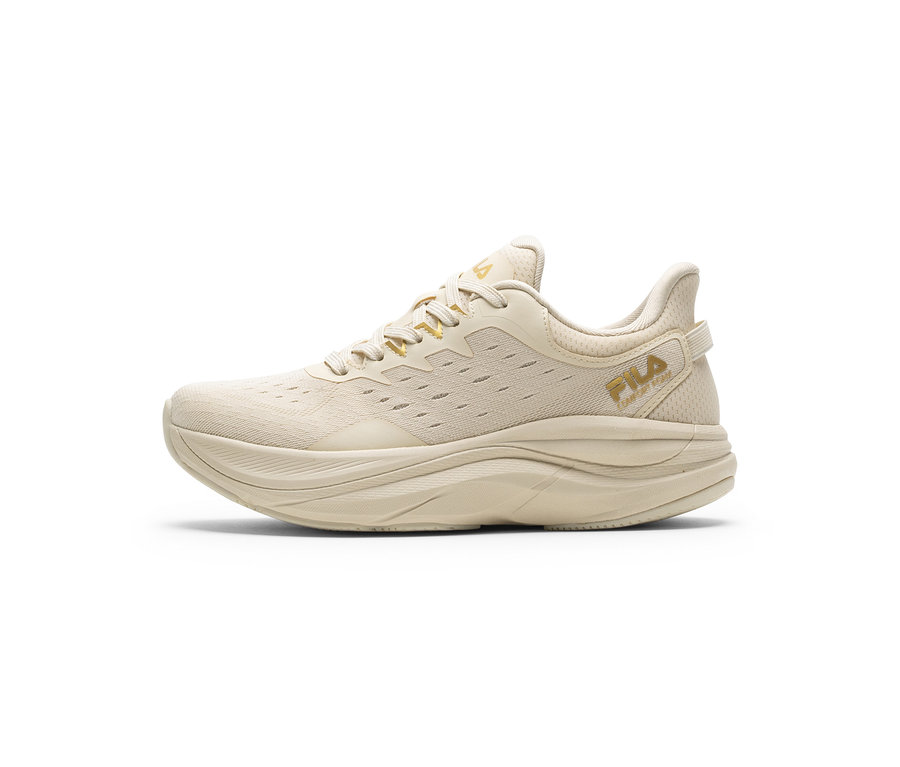 Jedna světle béžová sportovní bota s tlustou podrážkou a síťovaným svrškem. Zlatá loga „FILA“ jsou na boku a na jazyku.