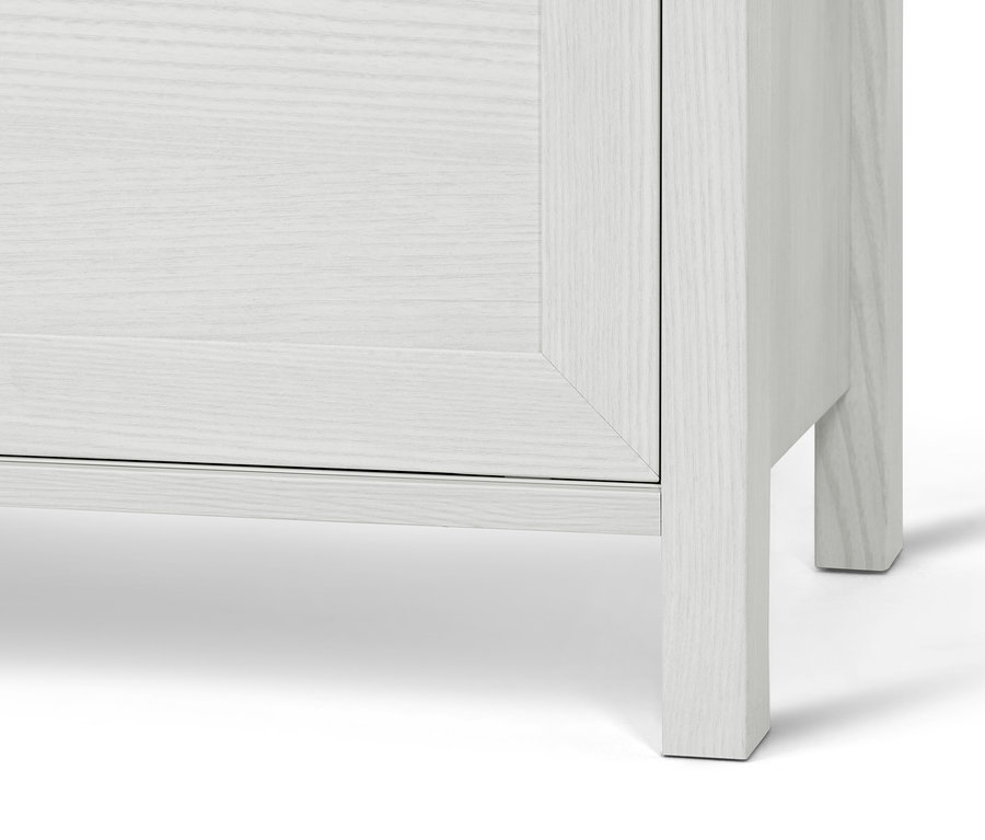 Detail bílého příborníku s úložným prostorem.