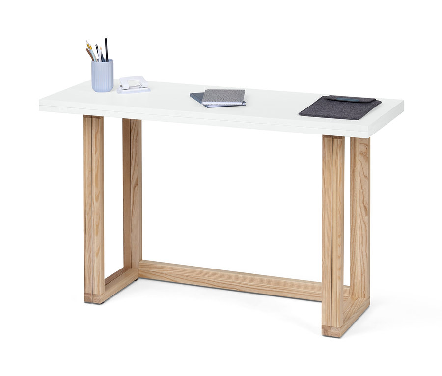 Bílý jídelní a pracovní stůl s dřevěnýma nohama. Na stole jsou psací potřeby, sešívačka, zápisníky a obal na dokumenty.