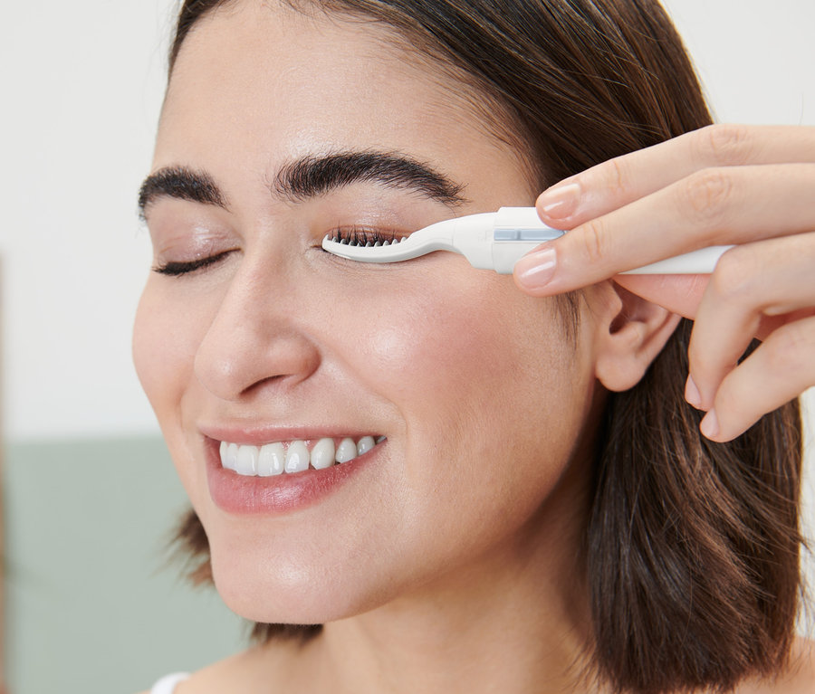 Žena používá vyhřívanou kulmu na řasy.