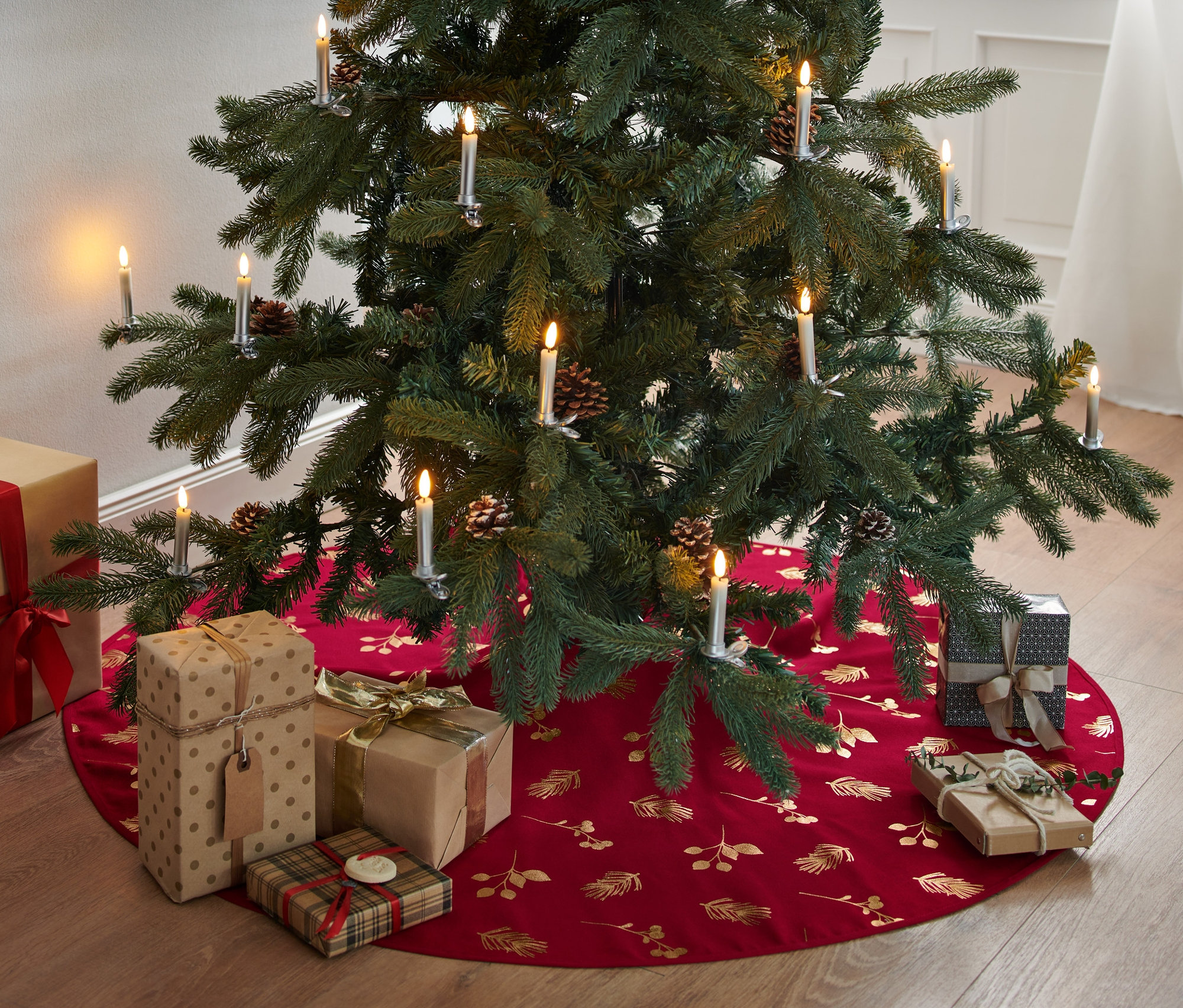 Dárky leží pod vánočním stromečkem na podložce pod vánoční stromeček.