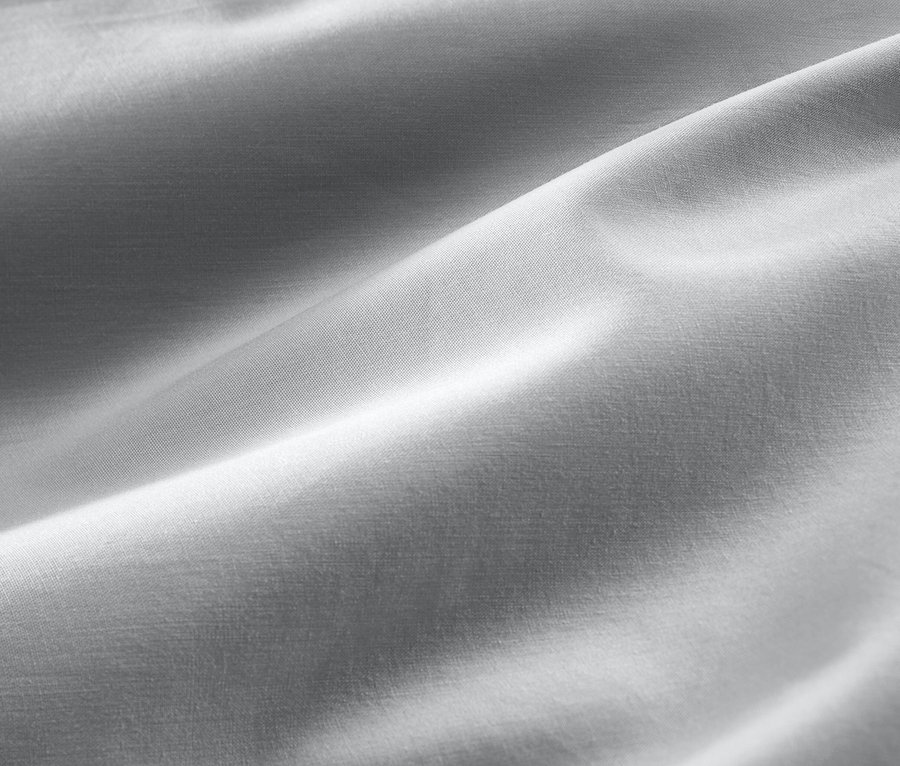 Detail šedého bavlněného saténového povlečení standardní a nadměrné velikosti.