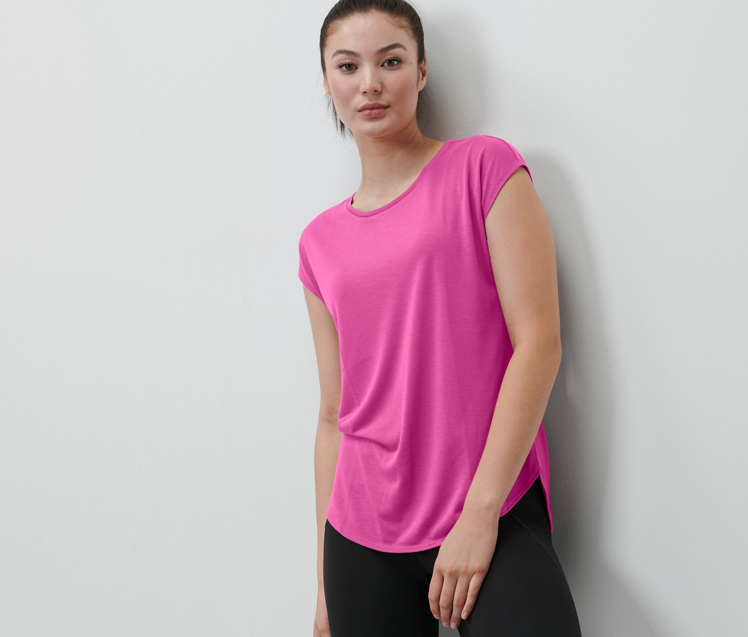 Žena má na sobě růžové sportovní tričko.