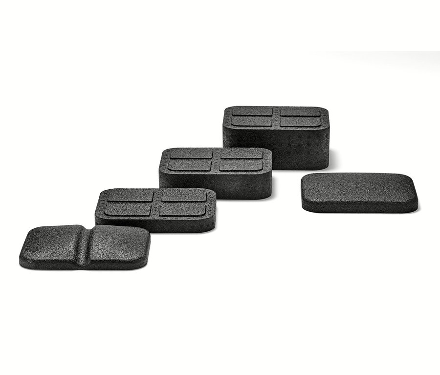 Čtyři černé pomůcky na uvolnění zad na bílém pozadí.