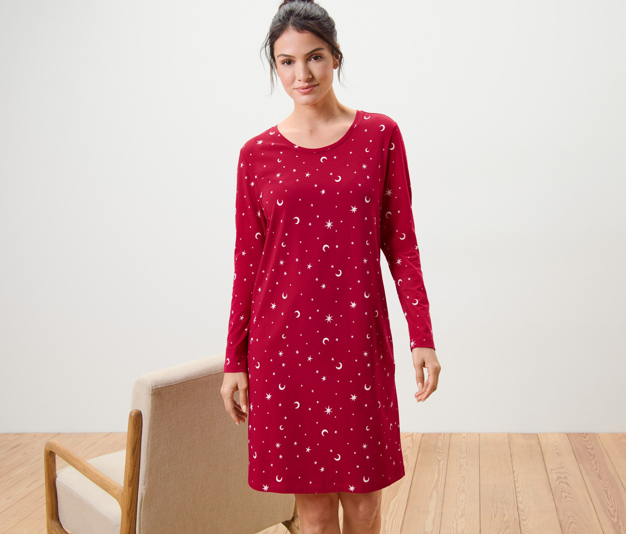 Žena stojí a má na sobě červenou noční košili.