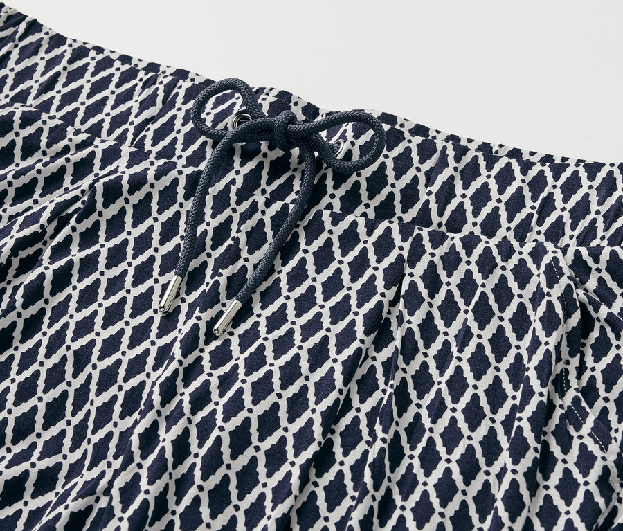 Detail vzorovaných žerzejových kalhot.