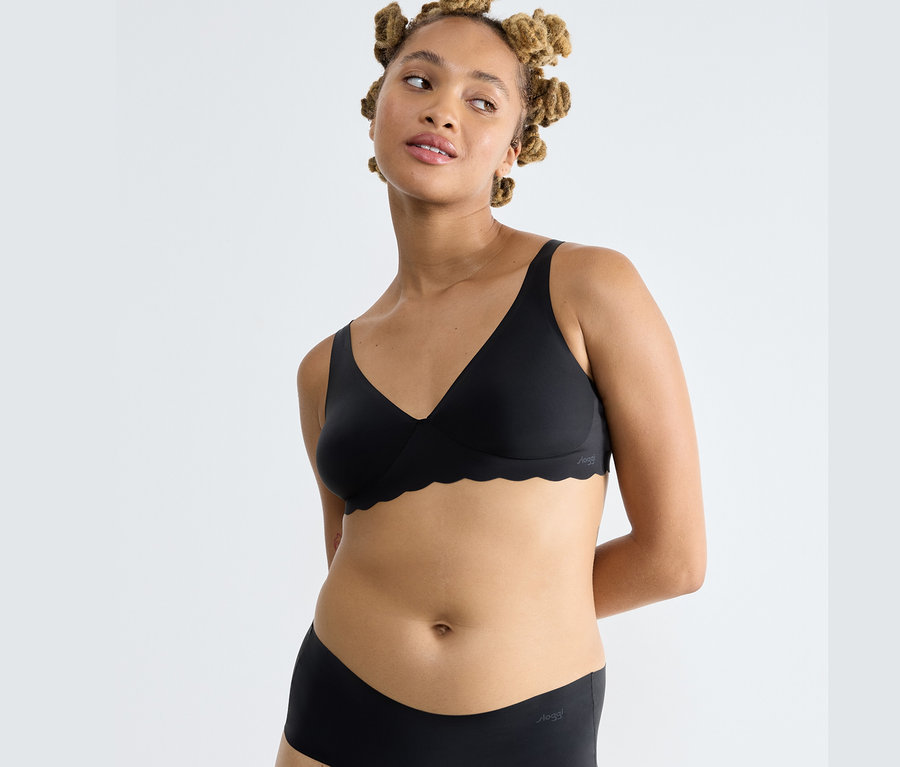 Žena má na sobě černou podprsenku sloggi ZERO Microfibre 2.0 Soft bra a černé kalhotky.