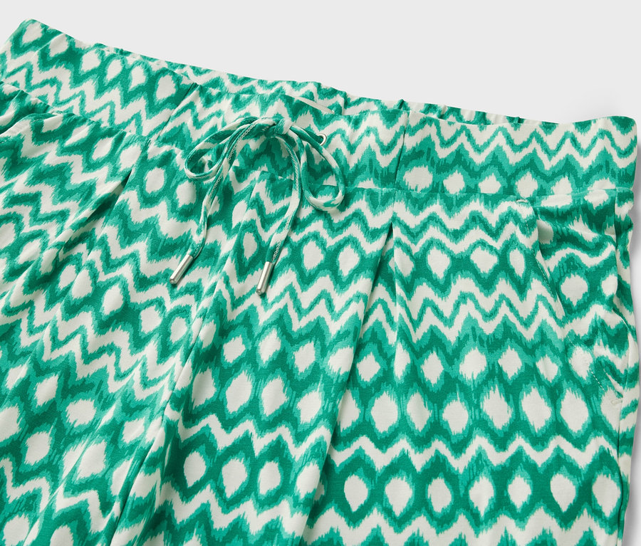 Detail dámských 3/4 žerzejových kalhot s potiskem.