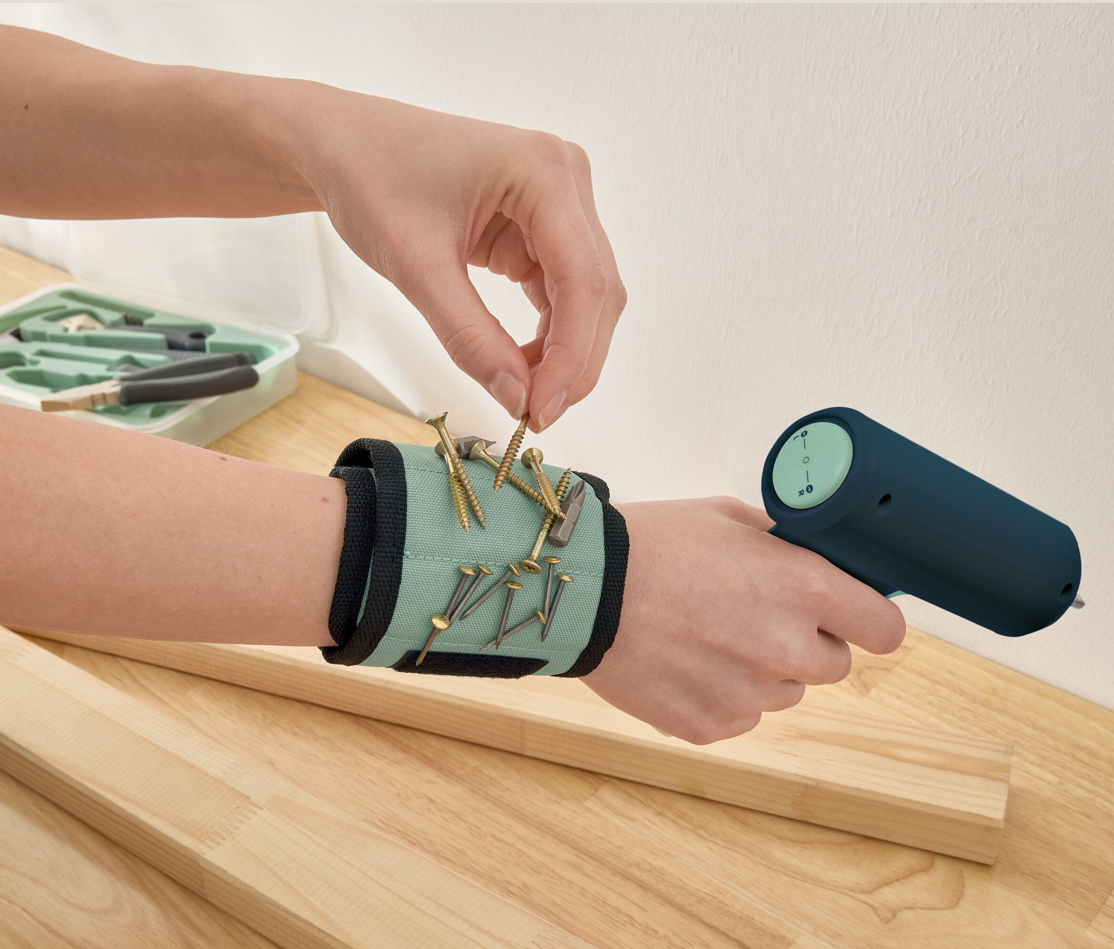 Ruka sbírá šroub z magnetického náramku.