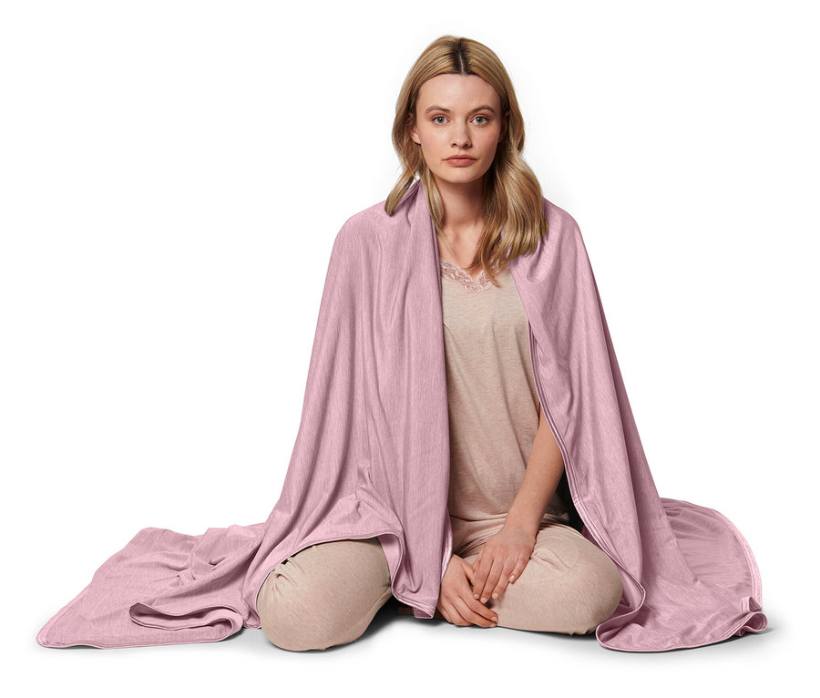 Žena sedí s růžovou chladivou dekou.