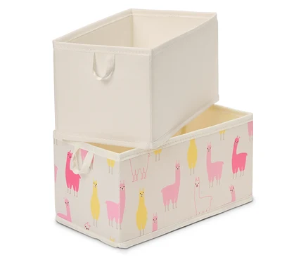 Dva obdélníkové úložné boxy jsou naskládány na sobě. Horní box je jednobarevný béžový, spodní box je potištěný růžovými a žlutými lamami na béžovém pozadí.