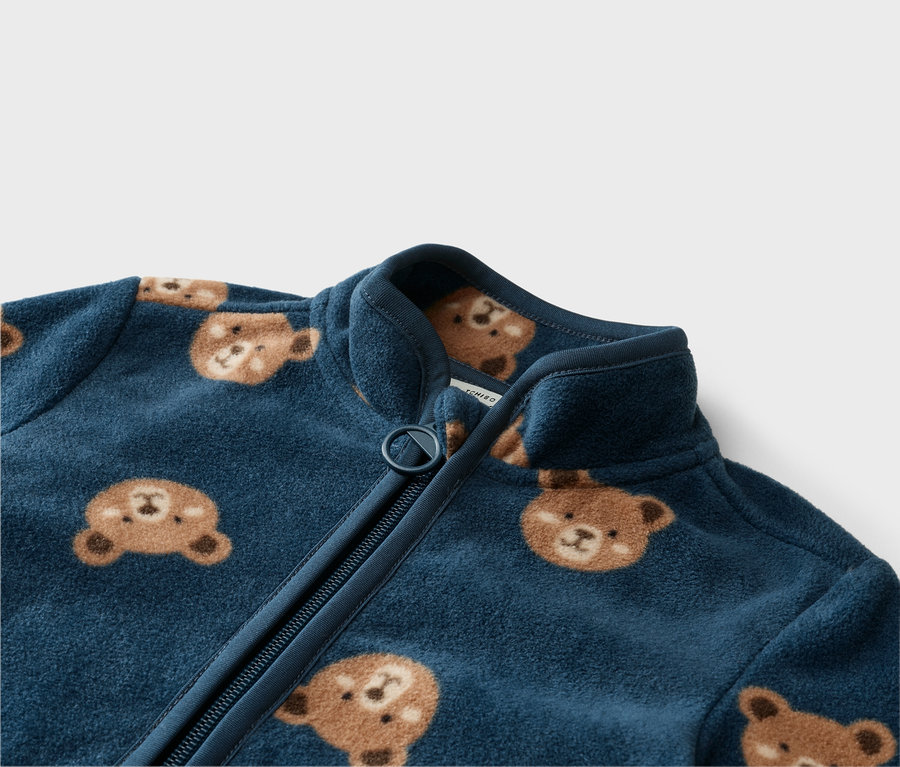 Detail modré fleecové bundy na zip s medvídky.