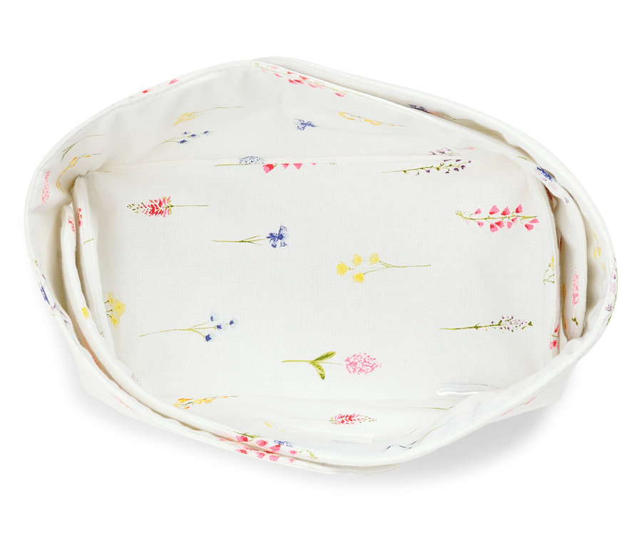 Pohled shora na prázdný košík na chléb potažený látkou s květinovým vzorem.