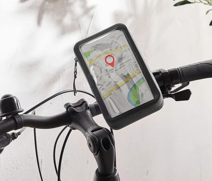Černé jízdní kolo s držákem na mobilní telefon na řídítkách, který zobrazuje mapovou aplikaci s červeným špendlíkem.