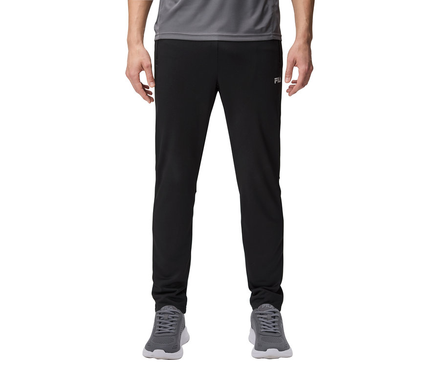 Muž má na sobě černé tepláky a šedé tenisky.