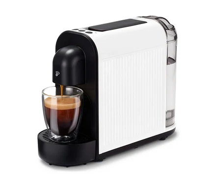 Kávovar Cafissimo now white plní šálek kávou. Kávovar je bílý s černými akcenty a průhlednou nádržkou na vodu.