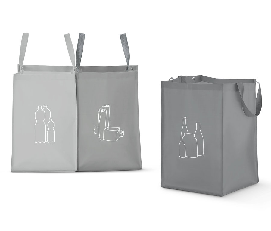 Šedé tašky na třídění odpadu s bílými ikonami recyklovaných plastových lahví, papíru a skla.