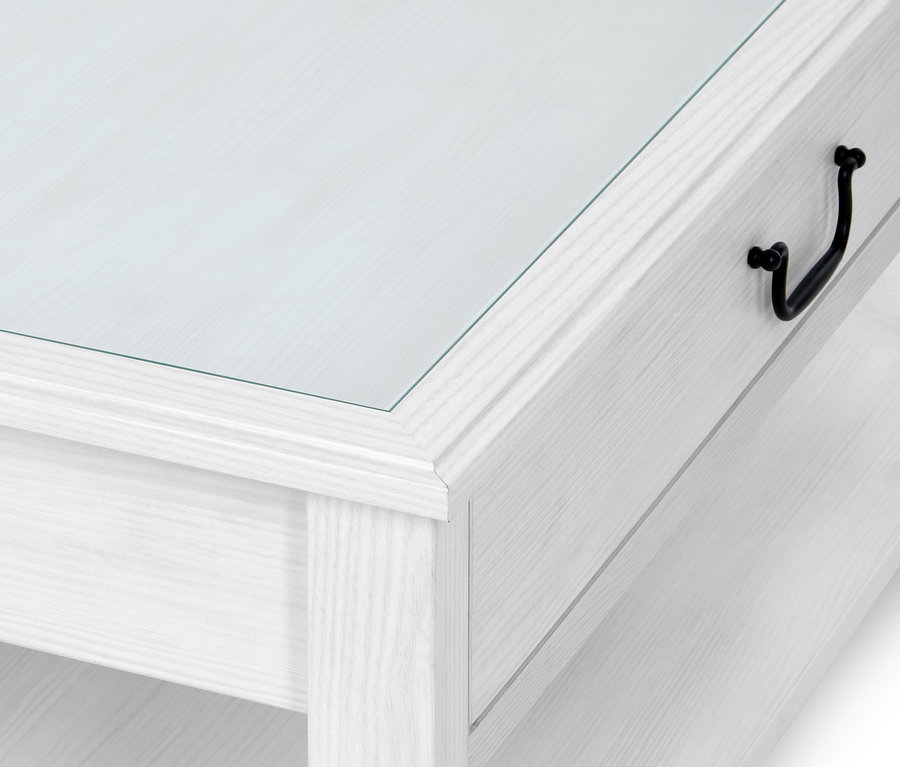 Detail bílého konferenčního stolku se skleněnou deskou.