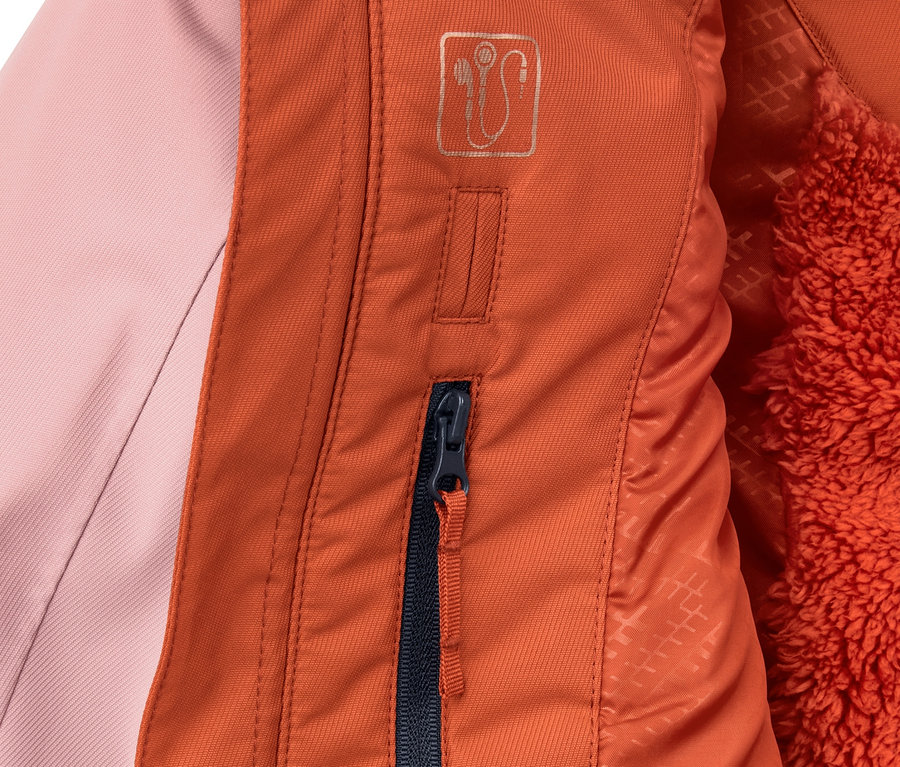 Detail bundy na lyže a snowboard s barevným blokováním, ukazující oranžový zip a růžovou látku.