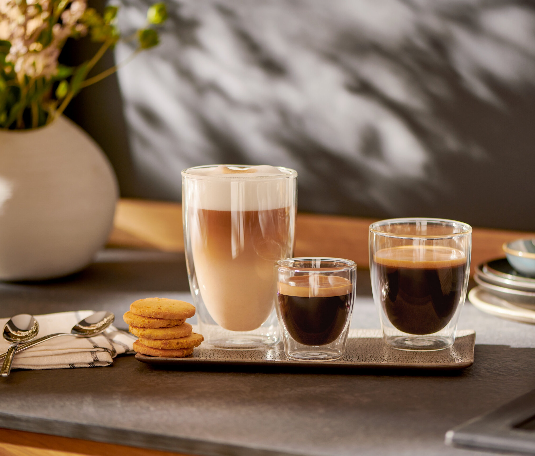 Na podnosu stojí sklenice na Caffè Crema a 2 dvoustěnné sklenice na Espresso.