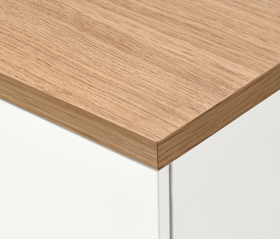 Detail rohu skříňky na boty »Bekeson« s dřevěnou deskou a bílými dvířky.