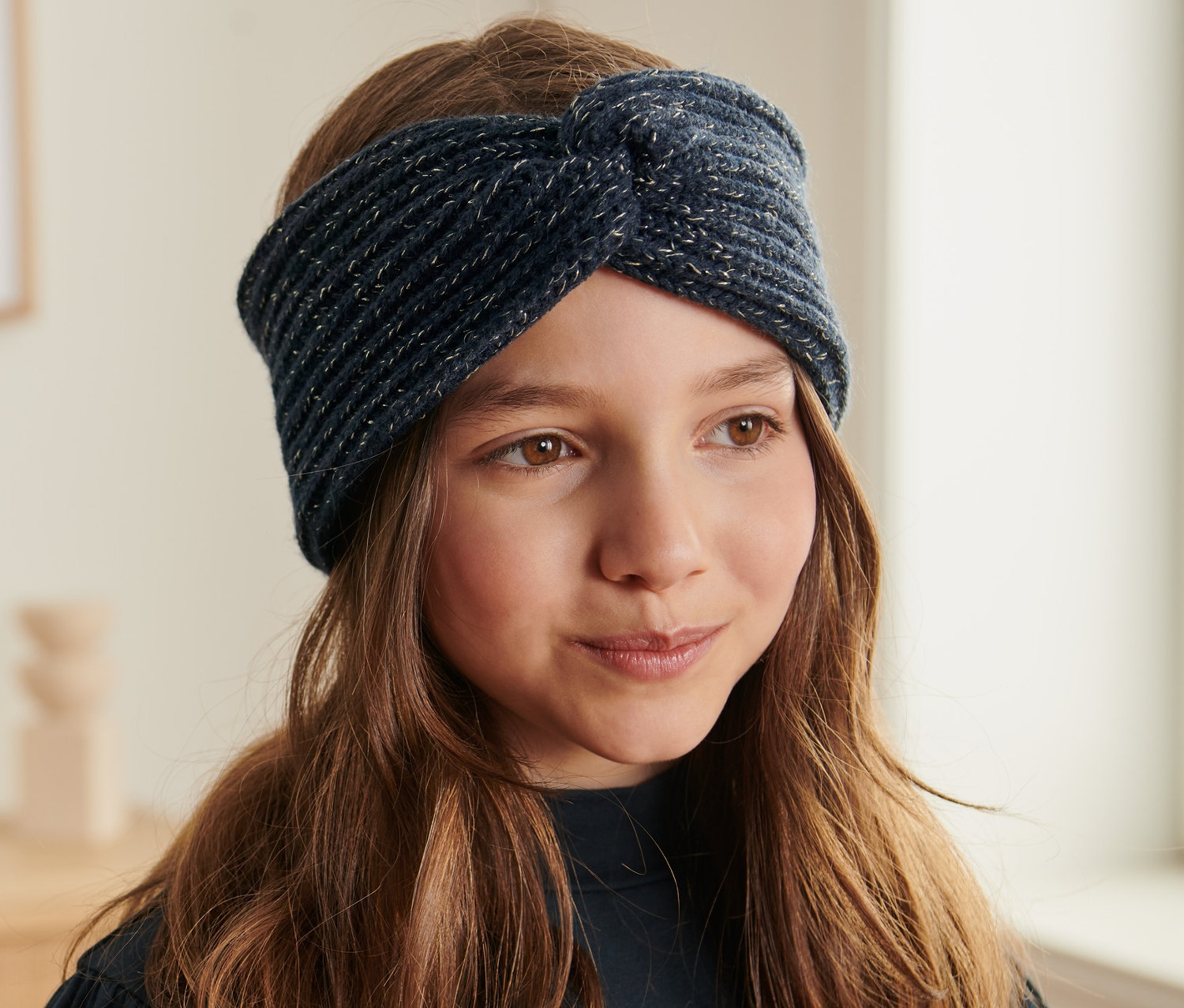 Dívka s dětskou pletenou čelenkou.