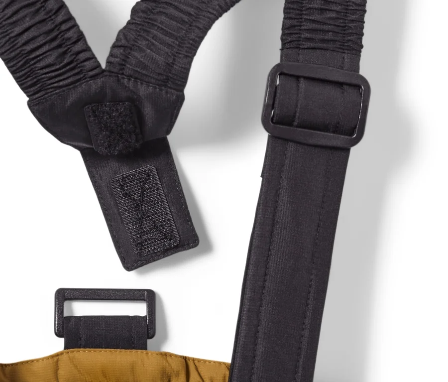 Detail dětských lyžařských kalhot velbloudí barvy se suspensory.