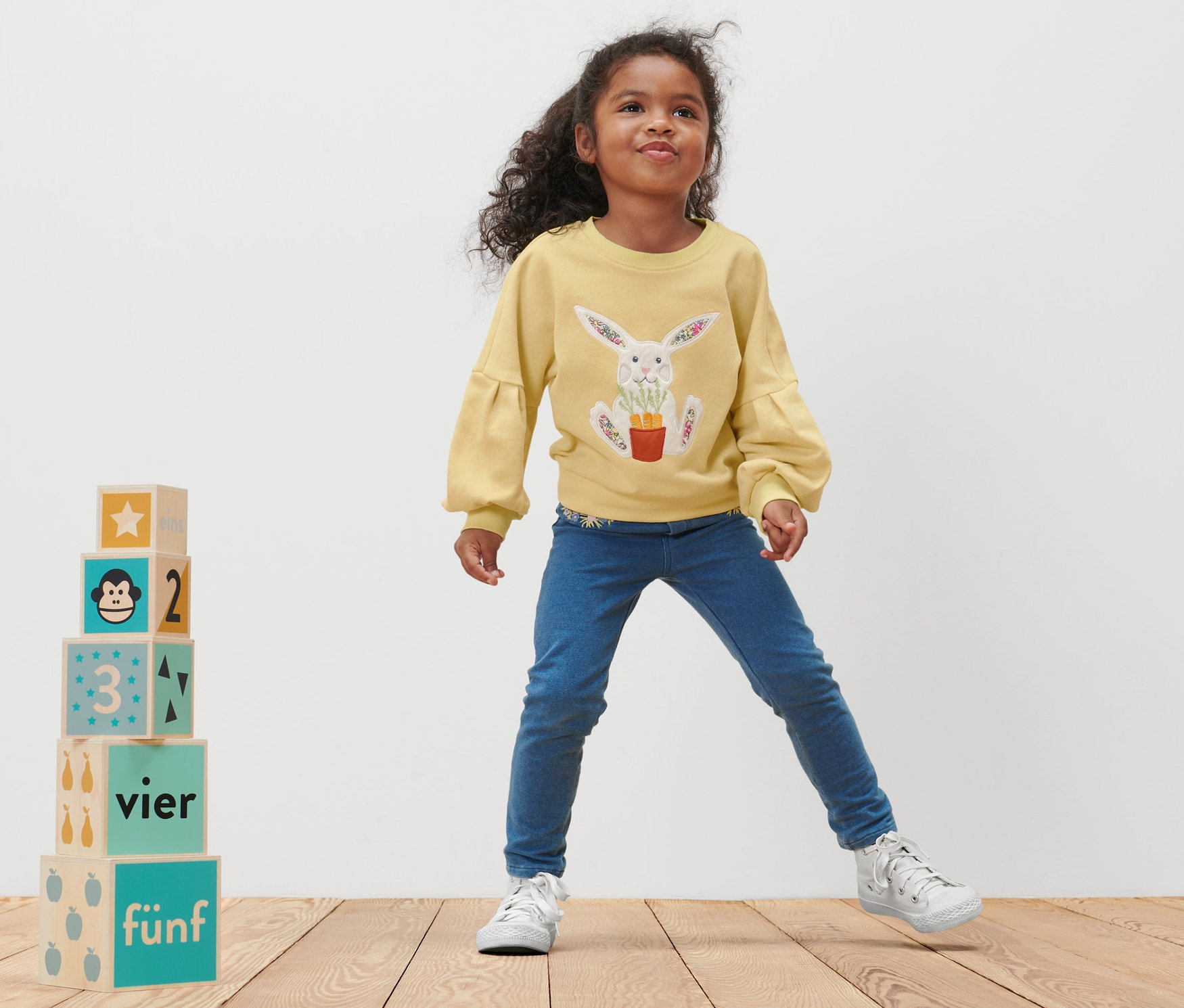 Holčička pózuje v dětské mikině s potiskem králíka.