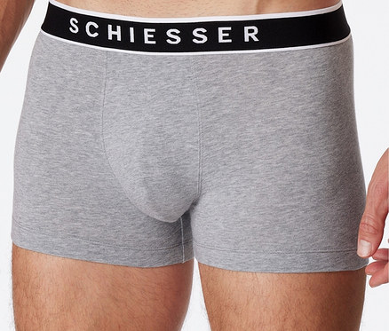 Muž pózuje ve světle šedých boxerkách SCHIESSER s biobavlnou, 3 ks.