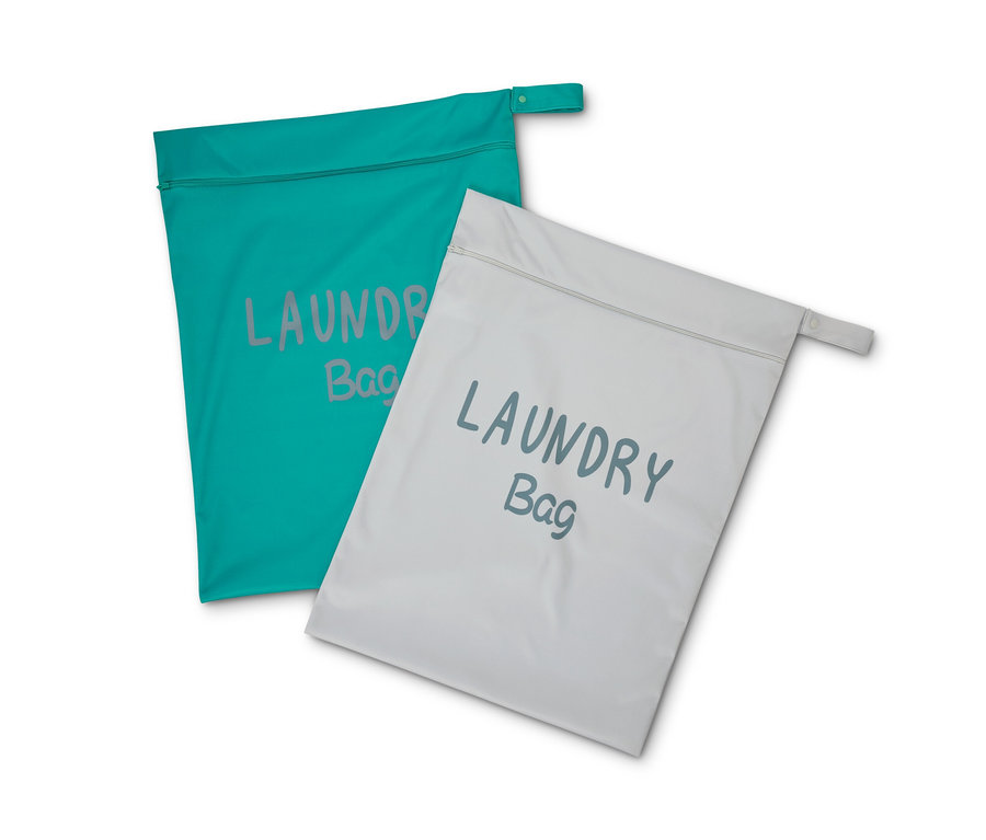 Dva cestovní pytle na špinavé prádlo, jeden tyrkysový a jeden šedý.