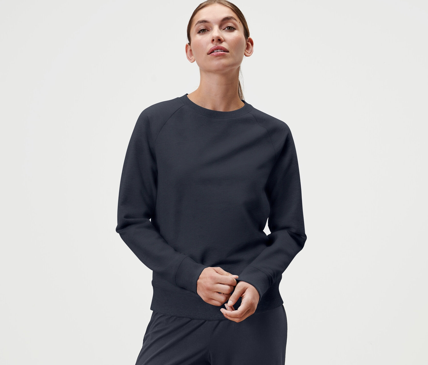 Žena má na sobě námořnickou modrou mikinu na jógu.