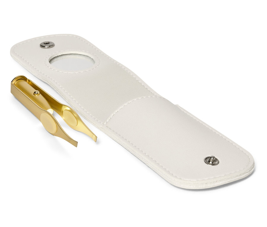 Zlatá pinzeta leží vedle otevřeného bílého pouzdra.