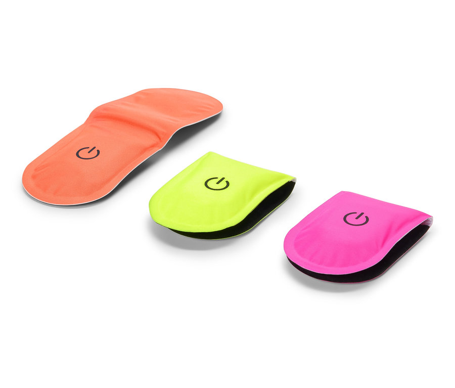 Oranžová vložka do boty leží vedle žluté a růžové blikačky.