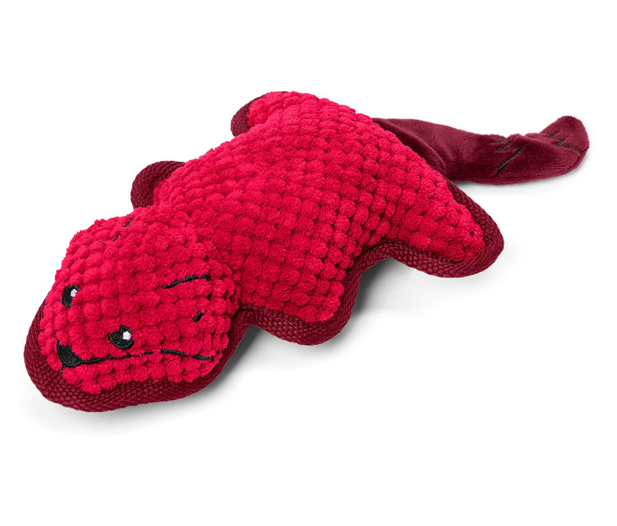 Červená plyšová hračka ve tvaru zvířete leží na bílém pozadí.