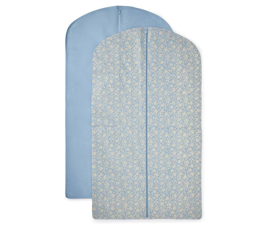 Dva obaly na oděvy: jeden světle modrý a jeden světle modrý s květinovým vzorem.