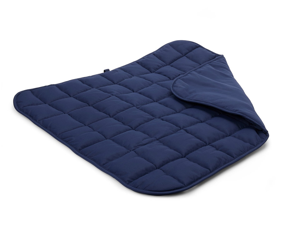 Detailní pohled na prošívanou tmavě modrou deku na bílém pozadí.