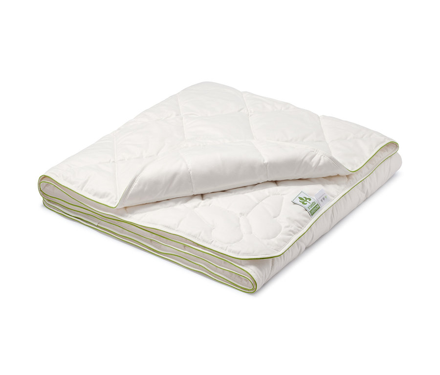 Složená bílá prošívaná přikrývka irisette® greenline z hedvábí a bavlny s lemováním zelené barvy.