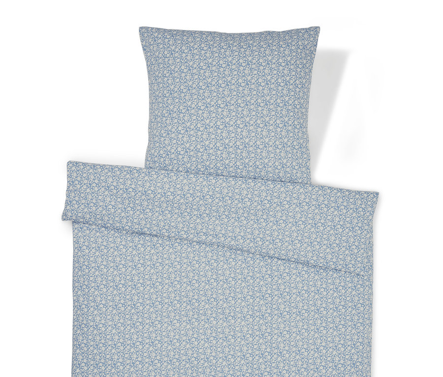 Povlečení s květinovým vzorem a polštářem.