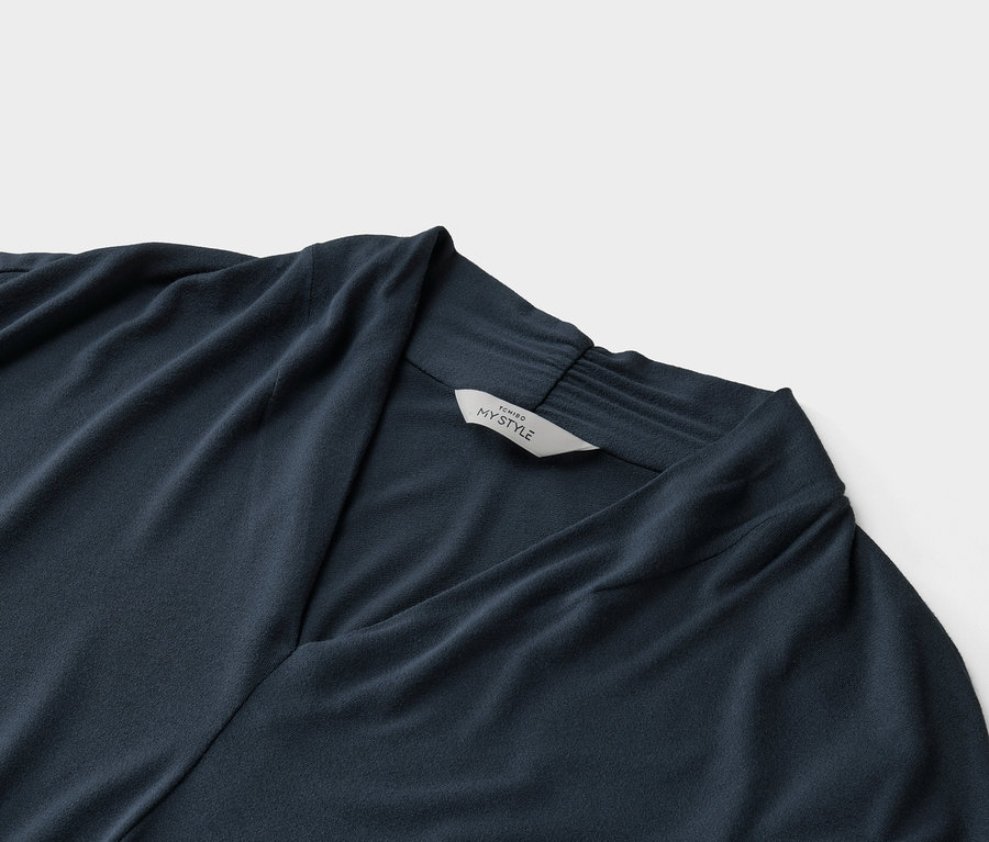 Detailní záběr tmavě modrého topu s výstřihem do V a štítkem s nápisem „Tchibo My Style“.