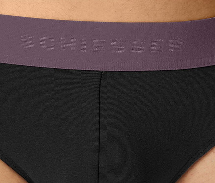 Detail pánských černých slipů s fialovým pasem značky Schiesser.