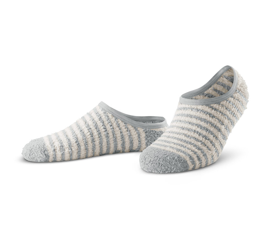 Dva páry ponožkových papučí s modrými a bílými pruhy leží na bílém pozadí.