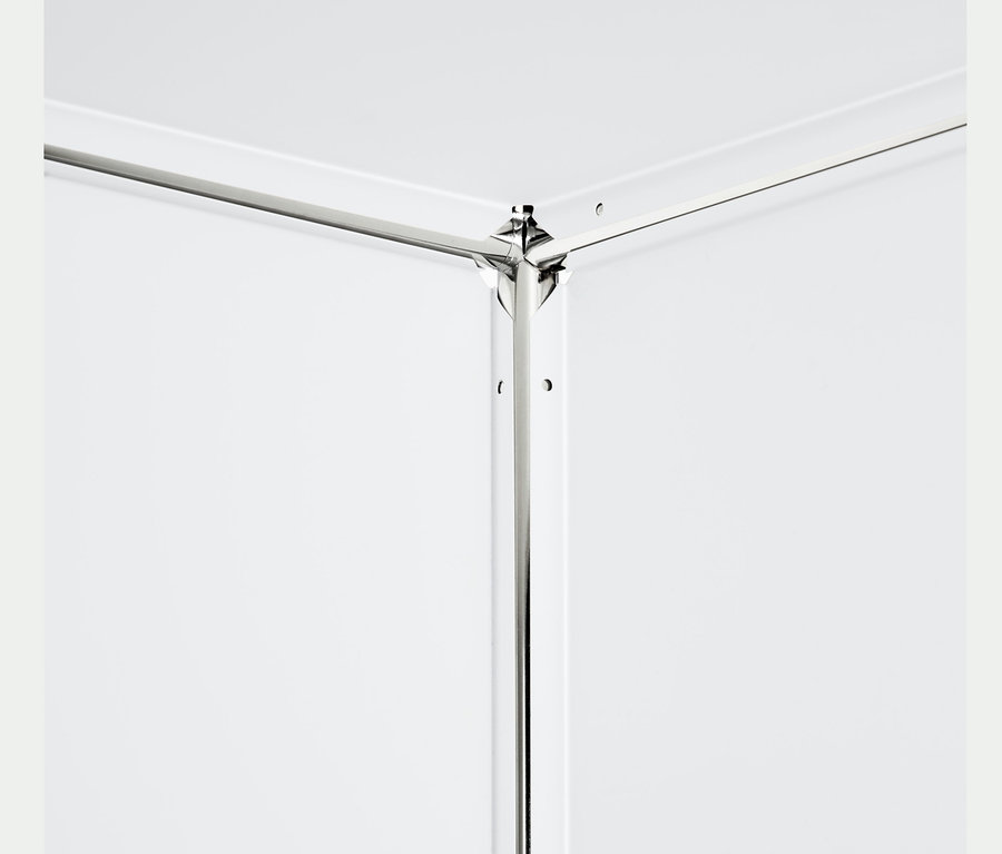 Detail bílého kovového regálu se 2 výklopnými dvířky.